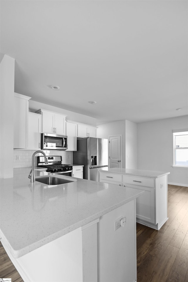 1072 Longstone Way, Spartanburg, SC 29306 - kitchen with stainless steel appliances, a peninsula, dark wood-style floors, a kitchen island, and white cabinets