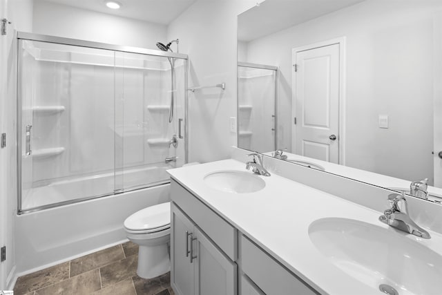 1072 Longstone Way, Spartanburg, SC 29306 - full bath featuring double vanity, bath / shower combo with glass door, toilet, stone finish flooring, and recessed lighting