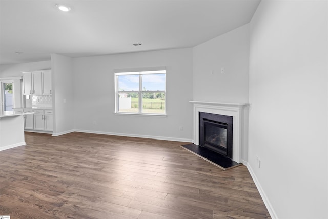 1072 Longstone Way, Spartanburg, SC 29306 - unfurnished living room with healthy amount of natural light, dark wood finished floors, a glass covered fireplace, baseboards, and recessed lighting