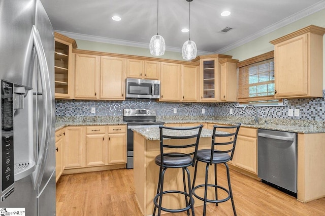 67 Devonhall Way, Taylors, SC 29687 - kitchen with appliances with stainless steel finishes, light brown cabinetry, ornamental molding, light wood-style flooring, and light stone countertops