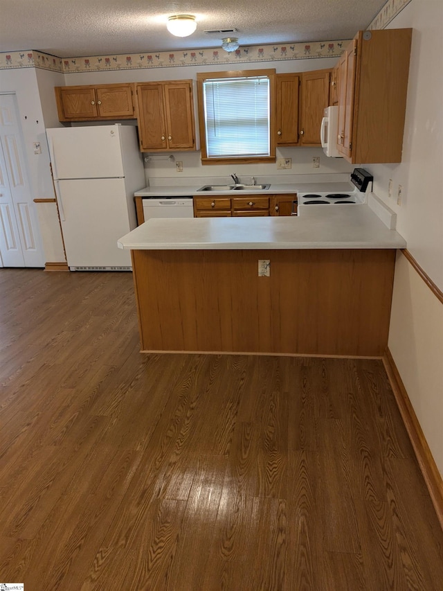 7 Willow Wood Ct, Taylors, SC 29687 - kitchen with white appliances, a sink, a peninsula, wood finished floors, and brown cabinetry