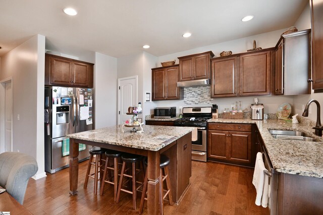 200 Marshfield Ct, Easley, SC 29642 - kitchen with stainless steel appliances, a sink, under cabinet range hood, light stone counters, and dark wood finished floors