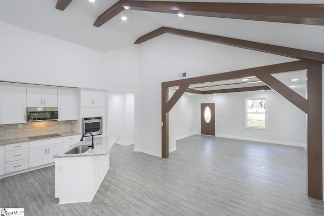 1008 Tribble St, Anderson, SC 29625 - kitchen featuring a sink, stainless steel appliances, beamed ceiling, decorative backsplash, and white cabinetry