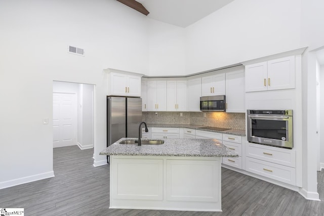 1008 Tribble St, Anderson, SC 29625 - kitchen featuring stainless steel appliances, a sink, a towering ceiling, baseboards, and white cabinetry