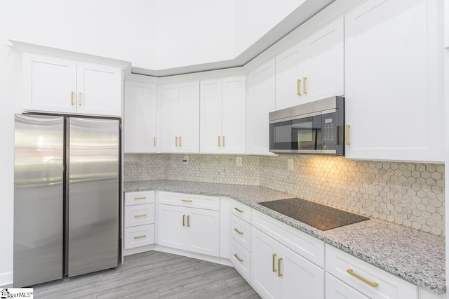 1008 Tribble St, Anderson, SC 29625 - kitchen featuring appliances with stainless steel finishes, white cabinetry, light stone counters, and backsplash