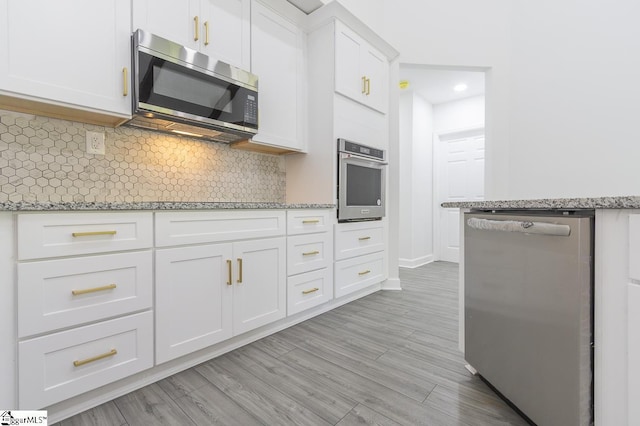 1008 Tribble St, Anderson, SC 29625 - kitchen featuring stainless steel appliances, tasteful backsplash, white cabinets, light stone countertops, and light wood-style floors
