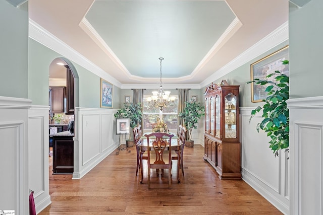 100 Claiborne Rd, Piedmont, SC 29673 - dining room featuring a tray ceiling, arched walkways, a decorative wall, a chandelier, and light wood-type flooring