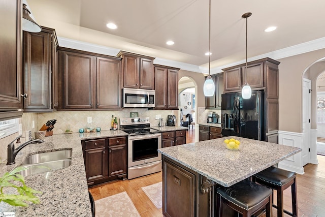 100 Claiborne Rd, Piedmont, SC 29673 - kitchen featuring arched walkways, stainless steel appliances, a sink, dark brown cabinets, and light stone counters