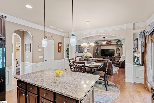 100 Claiborne Rd, Piedmont, SC 29673 - kitchen featuring arched walkways, open floor plan, light wood-style flooring, a decorative wall, and wainscoting