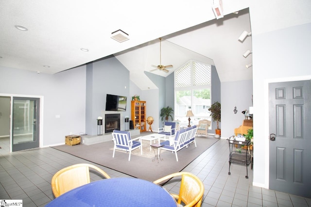 1507 Northlake Dr, Anderson, SC 29625 - dining area with ceiling fan, a fireplace with raised hearth, tile patterned floors, high vaulted ceiling, and baseboards