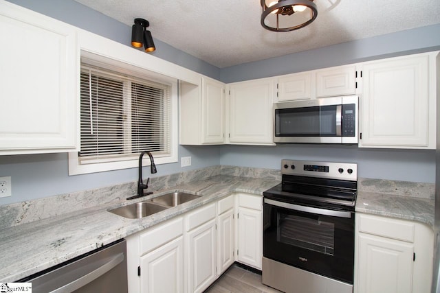 1507 Northlake Dr, Anderson, SC 29625 - kitchen featuring appliances with stainless steel finishes, a sink, a textured ceiling, white cabinets, and light wood-style flooring