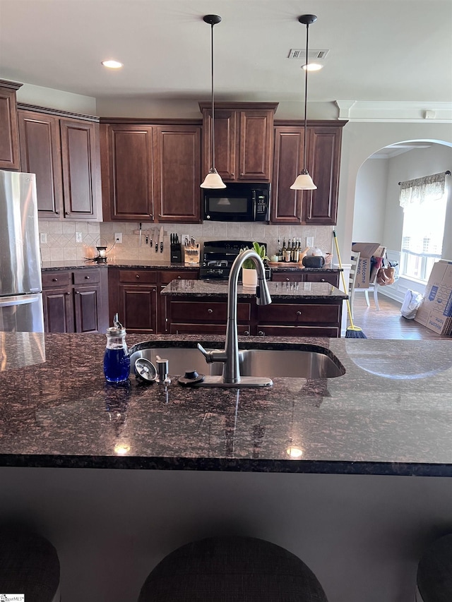112 Cameron Creek Ln, Simpsonville, SC 29681 - kitchen with black appliances, arched walkways, hanging light fixtures, dark brown cabinetry, and recessed lighting