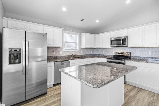 9023 Germaine Ct, Boiling Springs, SC 29316 - kitchen with appliances with stainless steel finishes, light wood-type flooring, white cabinets, a kitchen island, and tasteful backsplash