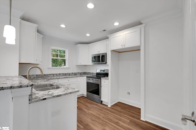 206 Daniels St, Anderson, SC 29625 - kitchen featuring stainless steel appliances, a sink, light wood finished floors, white cabinetry, and light stone counters