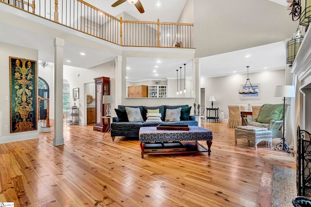 8 Knob Creek Ct, Greer, SC 29651 - living area featuring a high ceiling, light wood-style floors, ceiling fan, ornate columns, and arched walkways