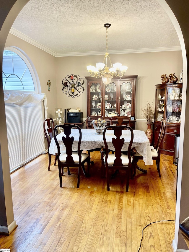 191 Amberwood Dr, Anderson, SC 29621 - dining area featuring arched walkways, a chandelier, a textured ceiling, light wood-type flooring, and ornamental molding