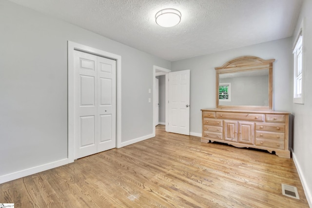 103 Cumbahee Trl, Greenville, SC 29611 - unfurnished bedroom with light wood-style flooring, a textured ceiling, baseboards, and a closet