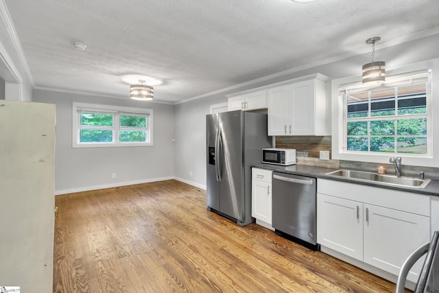 103 Cumbahee Trl, Greenville, SC 29611 - kitchen with appliances with stainless steel finishes, a sink, crown molding, white cabinetry, and a textured ceiling