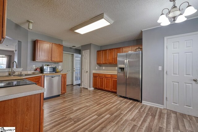 406 Standing Rock Dr, Boiling Springs, SC 29316 - kitchen with stainless steel appliances, light wood-style floors, a textured ceiling, light countertops, and brown cabinets
