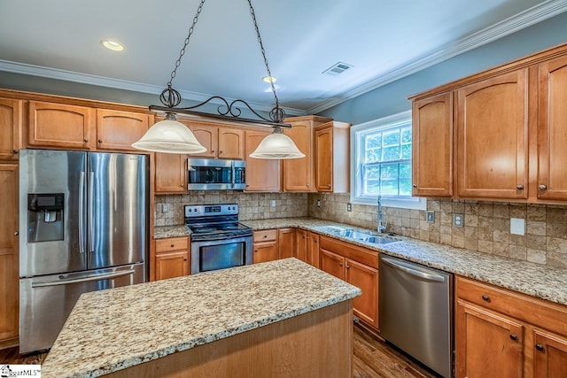 414 Mayburgh Ct, Spartanburg, SC 29301 - kitchen featuring appliances with stainless steel finishes, a sink, a center island, ornamental molding, and decorative light fixtures