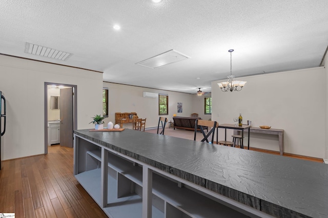 212 Middleton Shores Dr, Anderson, SC 29621 - kitchen featuring dark countertops, a textured ceiling, wood finished floors, a wall unit AC, and pendant lighting