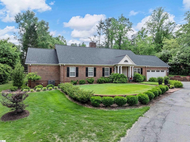 1076 Woodburn Rd, Spartanburg, SC 29302 - view of front of house featuring a garage, brick siding, a chimney, and asphalt driveway