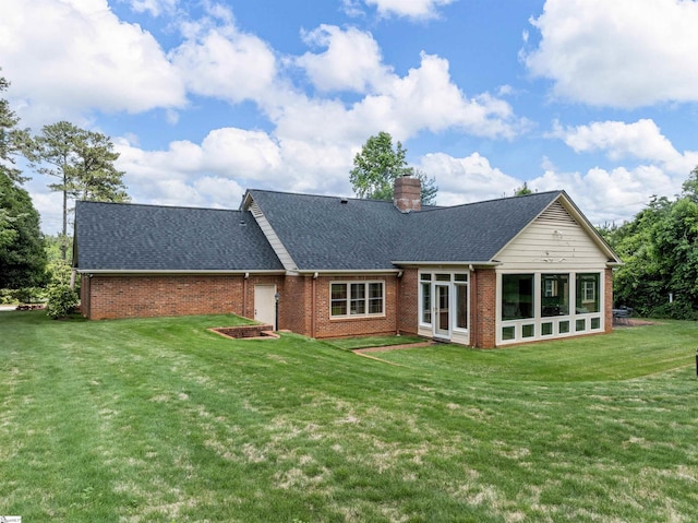 1076 Woodburn Rd, Spartanburg, SC 29302 - rear view of house with brick siding, roof with shingles, a lawn, a chimney, and a sunroom