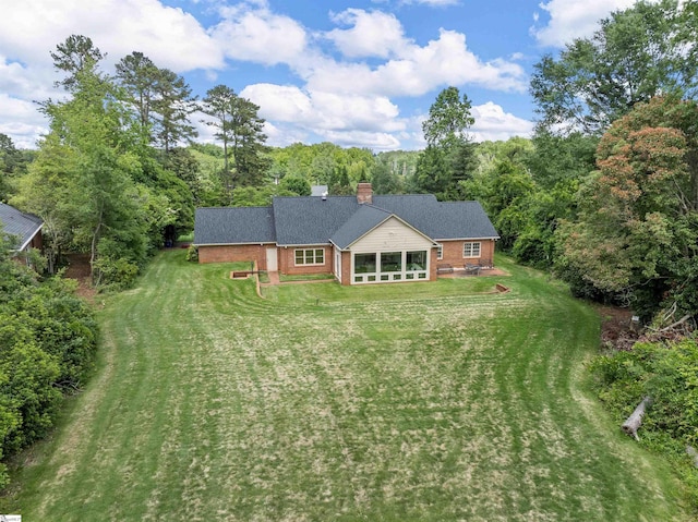 1076 Woodburn Rd, Spartanburg, SC 29302 - back of property featuring brick siding, a yard, a chimney, a sunroom, and a forest view