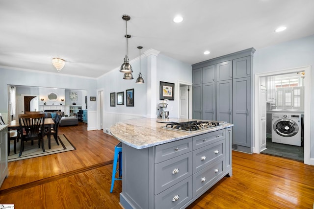 201 W Arlington Ave, Greer, SC 29650 - kitchen with washer / dryer, gray cabinets, stainless steel gas stovetop, wood finished floors, and open floor plan