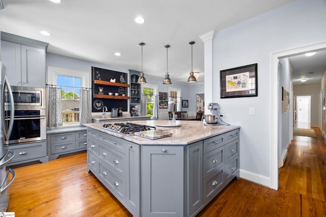 201 W Arlington Ave, Greer, SC 29650 - kitchen with gray cabinetry, appliances with stainless steel finishes, light wood-style flooring, light stone countertops, and pendant lighting