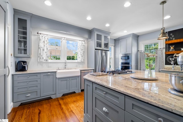 201 W Arlington Ave, Greer, SC 29650 - kitchen featuring gray cabinets, appliances with stainless steel finishes, a sink, wood finished floors, and backsplash