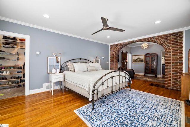 201 W Arlington Ave, Greer, SC 29650 - bedroom featuring arched walkways, ornamental molding, wood finished floors, a walk in closet, and baseboards