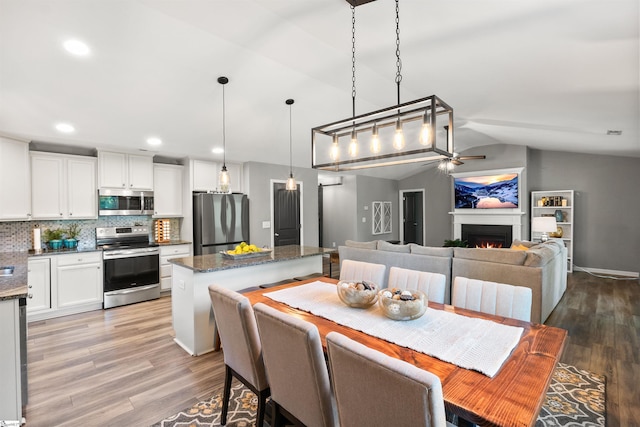 45 Lake Harbor Ct, Greer, SC 29651 - dining room featuring lofted ceiling, light wood-type flooring, a ceiling fan, a warm lit fireplace, and recessed lighting