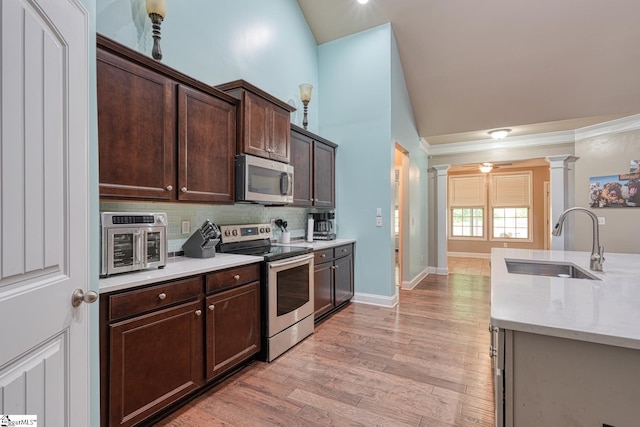 202 Buxton Ct, Easley, SC 29642 - kitchen with stainless steel appliances, ornate columns, a sink, dark brown cabinets, and backsplash