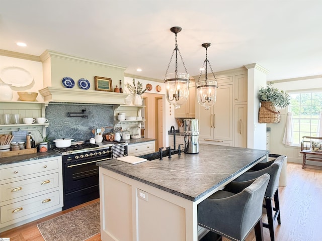 6050 Cross Anchor Rd, Enoree, SC 29335 - kitchen with range with two ovens, a sink, a kitchen breakfast bar, backsplash, and light wood-type flooring