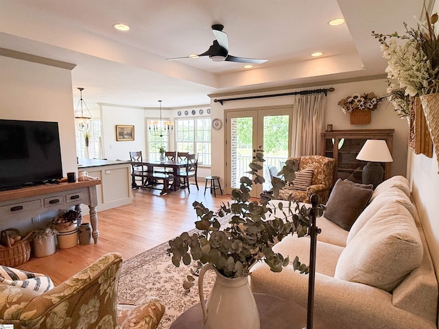 6050 Cross Anchor Rd, Enoree, SC 29335 - living room with a tray ceiling, ceiling fan, light wood finished floors, french doors, and a chandelier