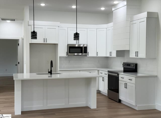 1623 Fairfield Rd, Chesnee, SC 29323 - kitchen featuring appliances with stainless steel finishes, a sink, light wood-style flooring, light countertops, and a kitchen island with sink