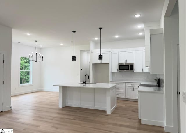 1623 Fairfield Rd, Chesnee, SC 29323 - kitchen with stainless steel microwave, backsplash, light wood-type flooring, white cabinetry, and recessed lighting