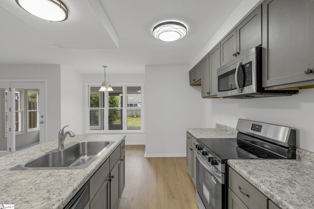 528 Market St, Spartanburg, SC 29301 - kitchen featuring appliances with stainless steel finishes, a sink, light wood-type flooring, light countertops, and hanging light fixtures