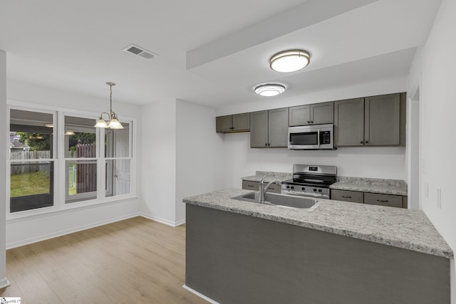528 Market St, Spartanburg, SC 29301 - kitchen featuring stainless steel appliances, a sink, light wood finished floors, pendant lighting, and baseboards