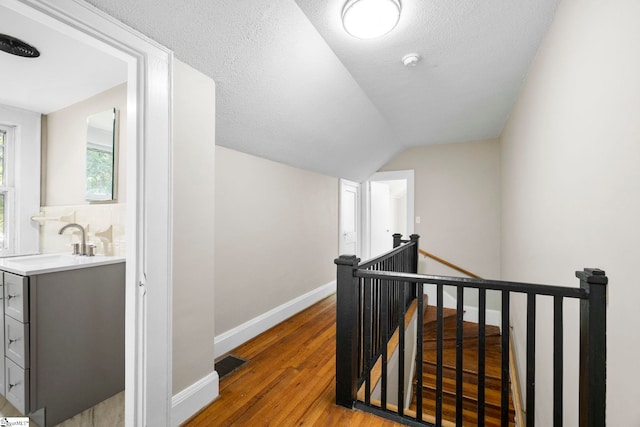 202 E Green St, Iva, SC 29655 - hallway featuring an upstairs landing, a sink, light wood finished floors, vaulted ceiling, and baseboards