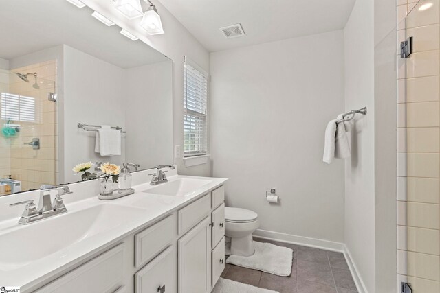 311 Sandusky Ln, Simpsonville, SC 29680 - full bathroom with a stall shower, double vanity, toilet, tile patterned floors, and baseboards