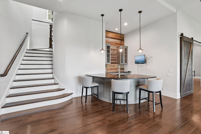 1110 Mountain Summit Rd, Travelers Rest, SC 29690 - kitchen with dark wood-type flooring, a barn door, glass insert cabinets, a breakfast bar, and recessed lighting