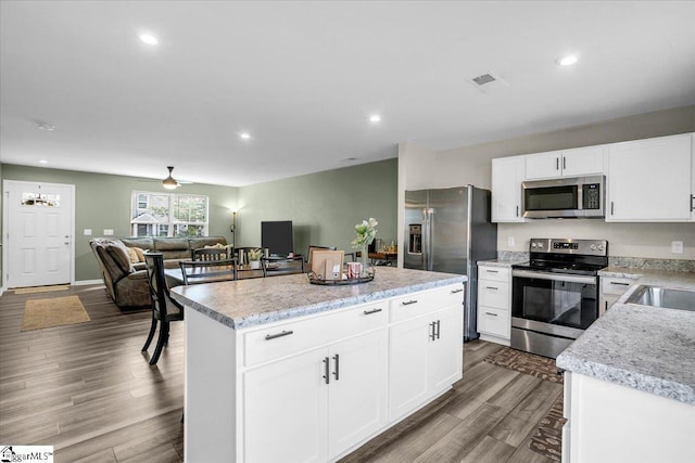 275 Ralston Rd, Greer, SC 29651 - kitchen featuring stainless steel appliances, wood finished floors, white cabinetry, a kitchen island, and recessed lighting