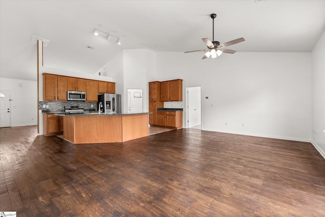 124 Bascom Ct, Greer, SC 29650 - kitchen featuring stainless steel appliances, rail lighting, an island with sink, brown cabinets, and high vaulted ceiling