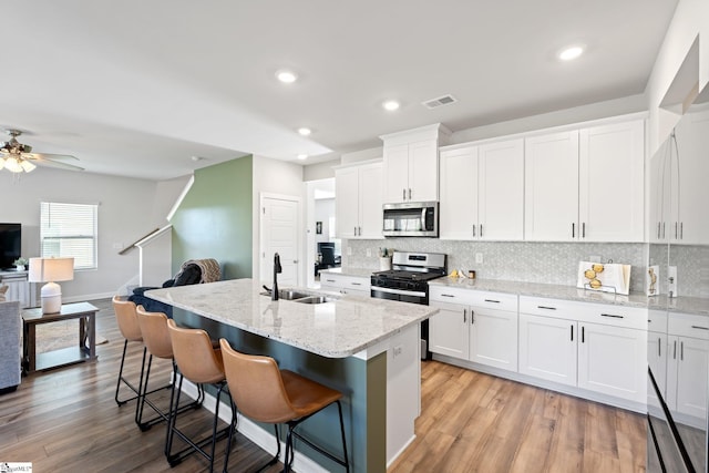 1019 Appalachian Dr, Moore, SC 29369 - kitchen featuring stainless steel appliances, a sink, tasteful backsplash, a kitchen bar, and white cabinets