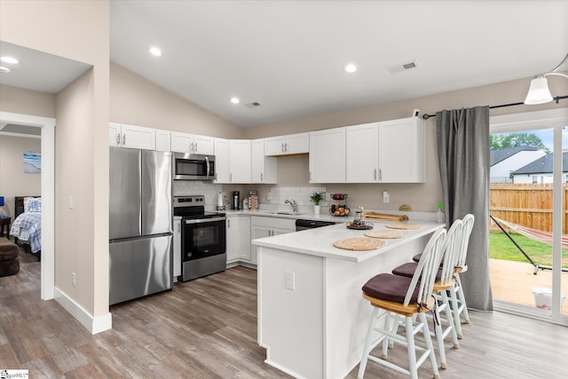 101 Sunrise Rd, Spartanburg, SC 29302 - kitchen featuring appliances with stainless steel finishes, a peninsula, light countertops, tasteful backsplash, and light wood-style floors