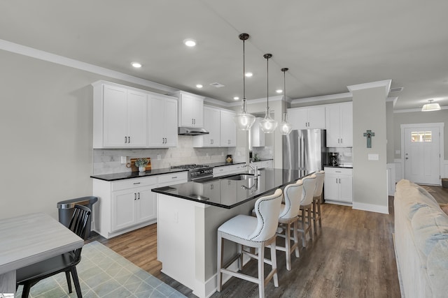 113 Marshfield Trl, Simpsonville, SC 29680 - kitchen with under cabinet range hood, crown molding, stainless steel appliances, dark countertops, and wood finished floors