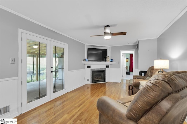 469 Royal Oak Dr, Spartanburg, SC 29302 - living room featuring light wood-style floors, crown molding, french doors, a wainscoted wall, and a ceiling fan
