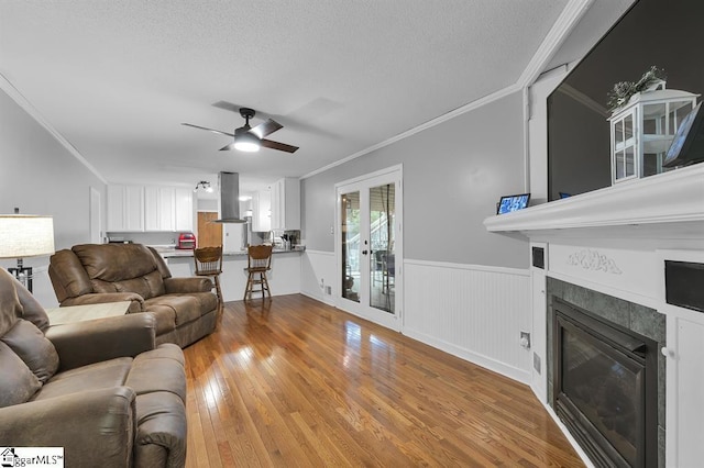 469 Royal Oak Dr, Spartanburg, SC 29302 - living area featuring crown molding, a tiled fireplace, wood finished floors, a ceiling fan, and wainscoting